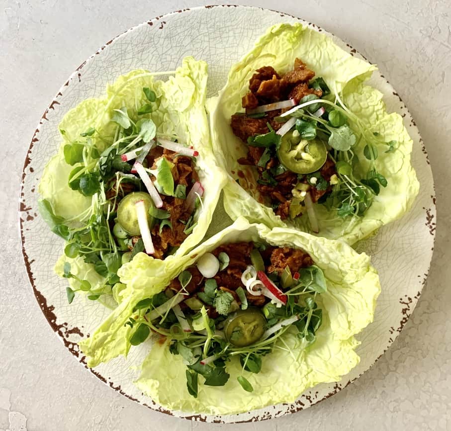 3 Vegan lettuce wraps made with plant based BBQ "pork" topped with watercress, radishes and pickled jalapeños for little extra kick!