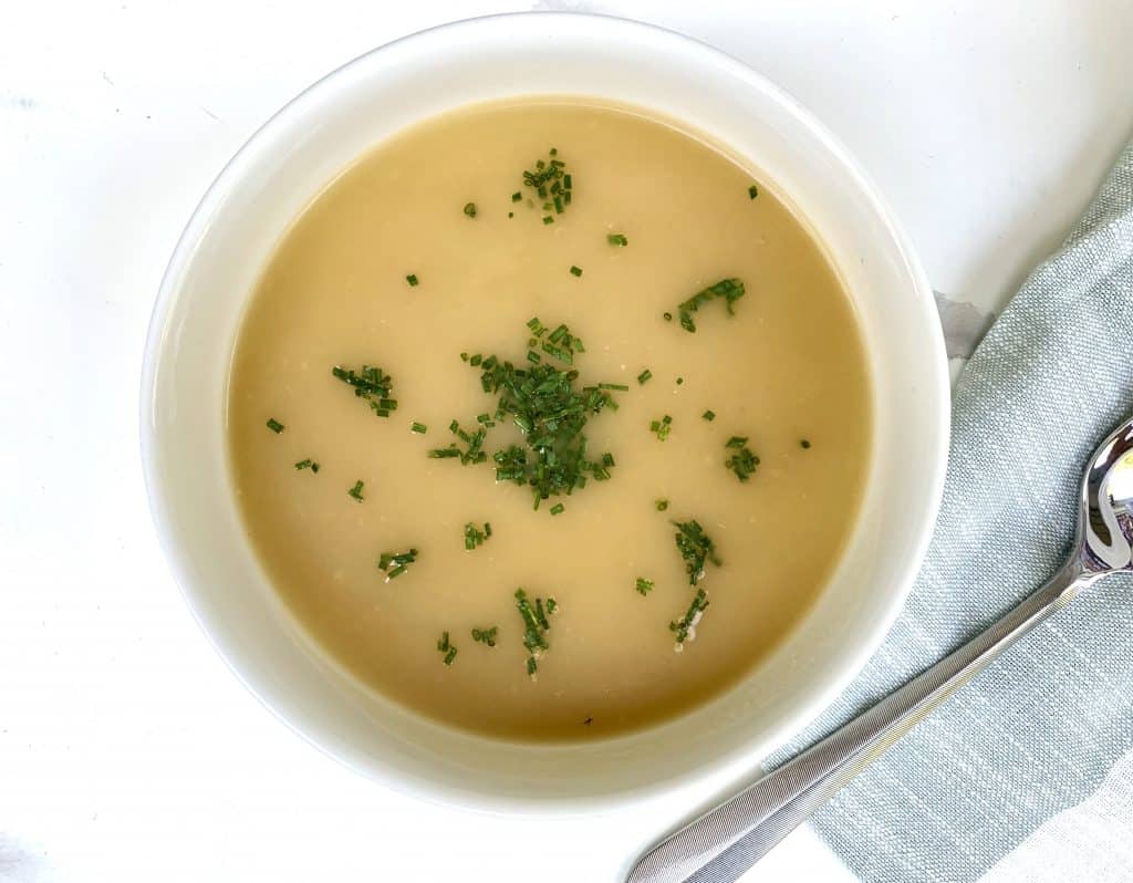 Vichyssoise Soup made with Potatoes, Cucumbers & Chives pictured in a bowl with a fork and a green napkin